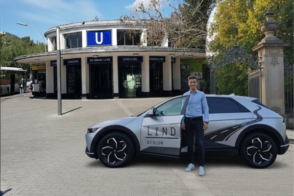 Fahrschulauto der Fahrschule Lind mit Logo vor dem Eingang des U-Bahnhofs Krumme Lanke in Berlin-Zehlendorf.
