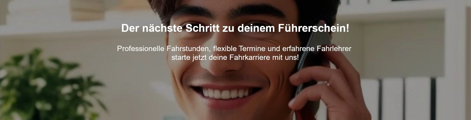 Junger Mann mit dunklen, modischen Haaren lächelt freundlich in die Kamera und telefoniert, im Hintergrund ein modernes Büro – Symbolbild für freundliche Beratung bei der Fahrschule Lind in Berlin.