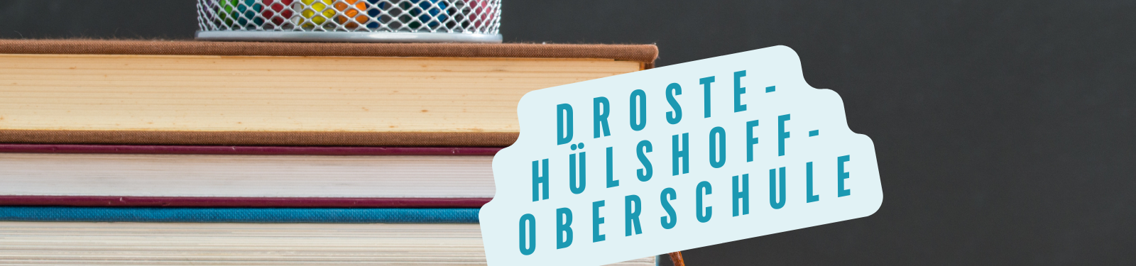 Stapel von Büchern mit einem Stiftehalter auf einem dunklen Hintergrund, daneben der Schriftzug 'Droste-Hülshoff-Oberschule' in blauen Buchstaben auf einem hellblauen Hintergrund.