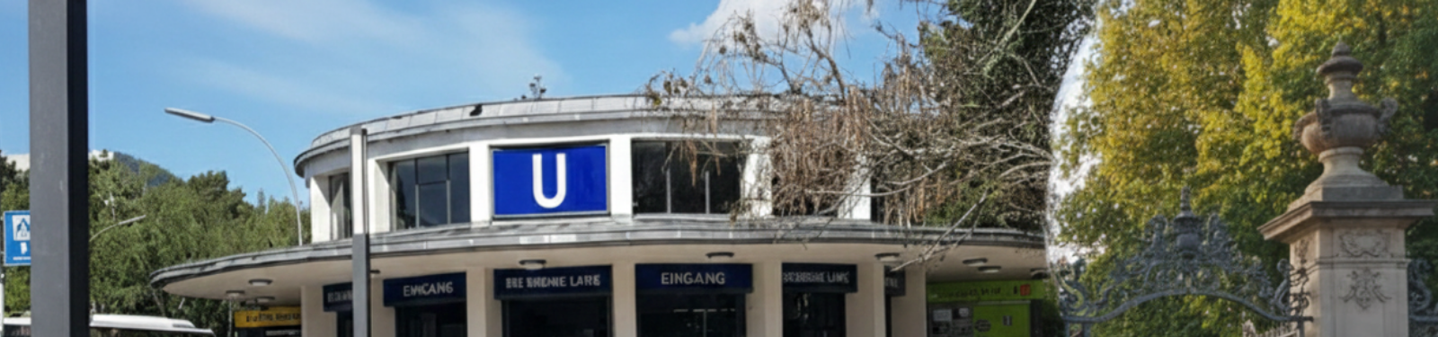 Eingangsbereich des U-Bahnhofs Krumme Lanke in Berlin-Zehlendorf mit großem U-Schild, Bäumen und Vorplatz.