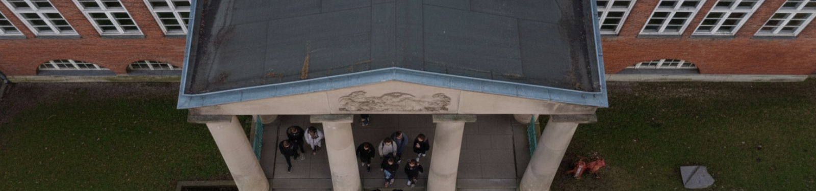 Fahrschule am Schadow-Gymnasium in Berlin-Zehlendorf – Luftaufnahme des Schuleingangs mit Säulen und Treffpunkt für Fahrschüler